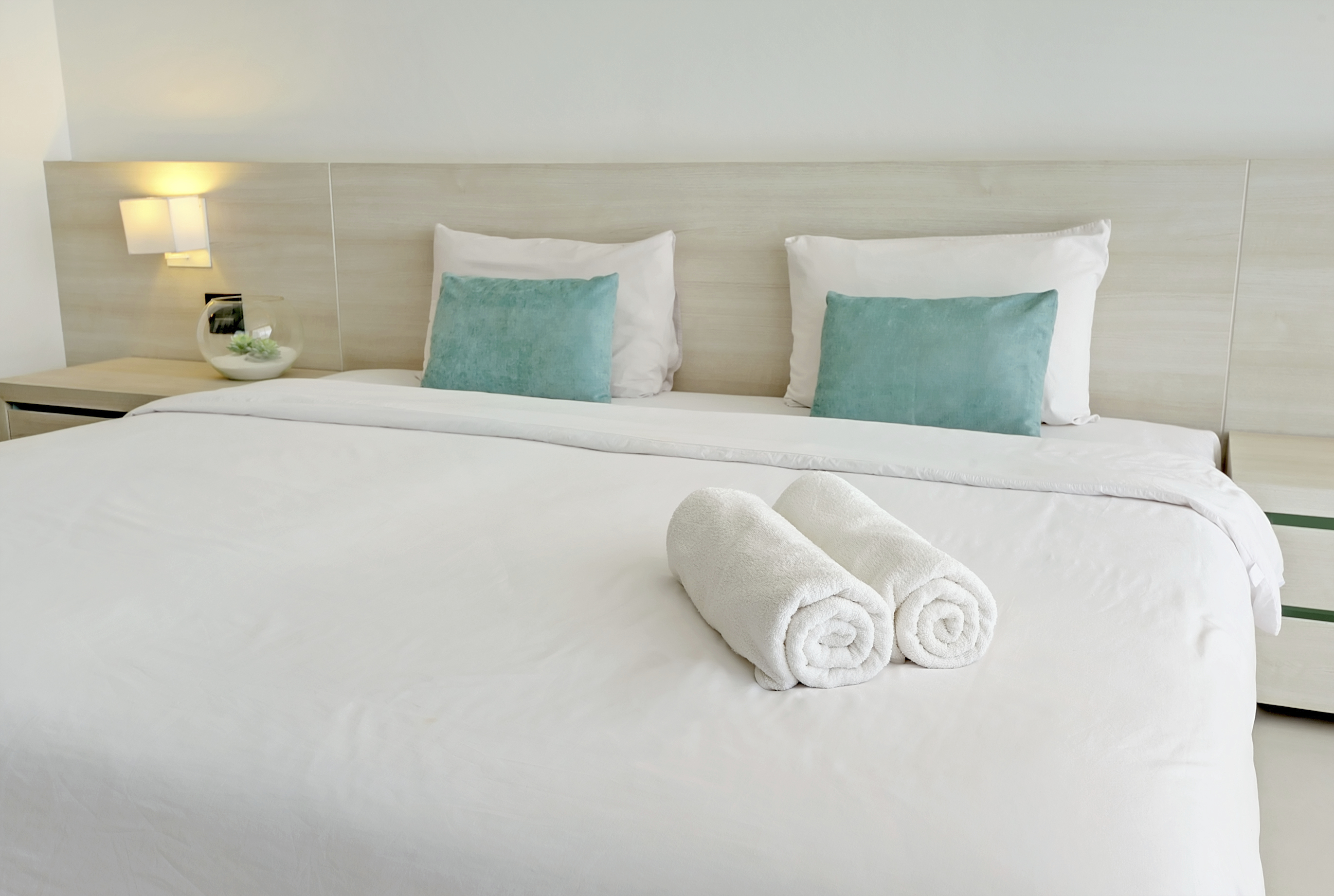 Полотенце на кровати. Текстиль для отелей. Постельное белье в отеле. Полотенца на кровати в отеле. Белая кровать в отеле.